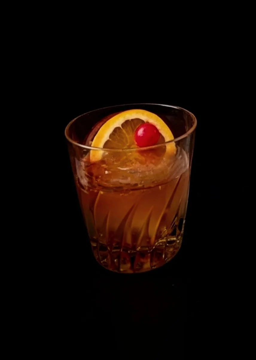 漆黒の背景に映えるオールド・ファッションド Authentic Bar STARS 2003。オレンジピールとチェリーを添えた一杯